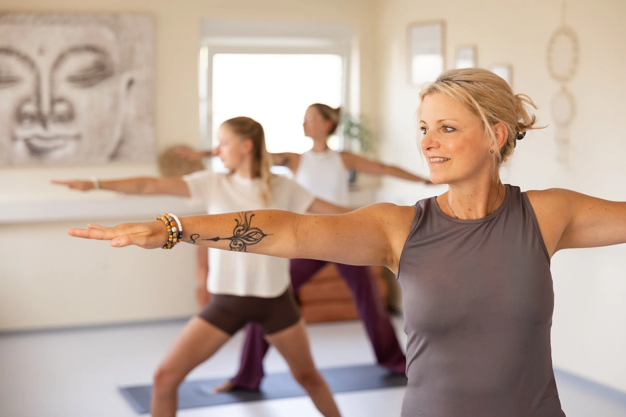 Gruppe übt gemeinsam Yoga im sonnendurchfluteten Studio